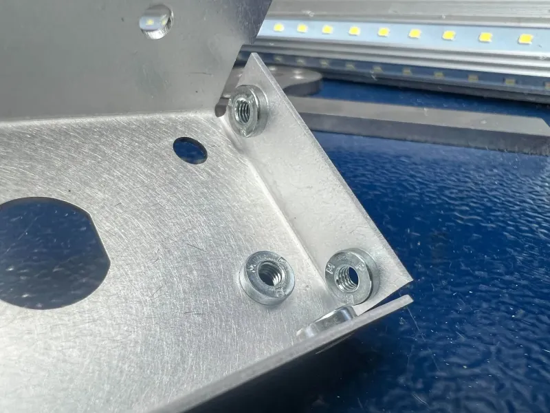 Zinc-plated PEM nuts installed in a bent aluminum sheet metal part